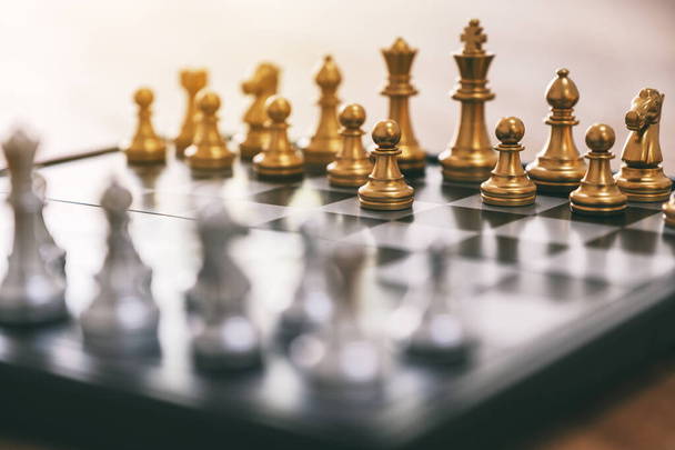 Closeup image of a silver and golden color chess set on chessboard - Photo, Image