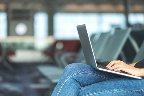 Una donna viaggiatore utilizzando il computer portatile mentre seduto in aeroporto - Foto, immagini