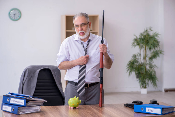 Starý zaměstnanec drží pušku v konceptu plánování rozpočtu - Fotografie, Obrázek