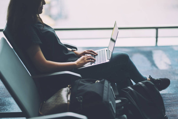 Una donna viaggiatore utilizzando il computer portatile mentre seduto in aeroporto - Foto, immagini