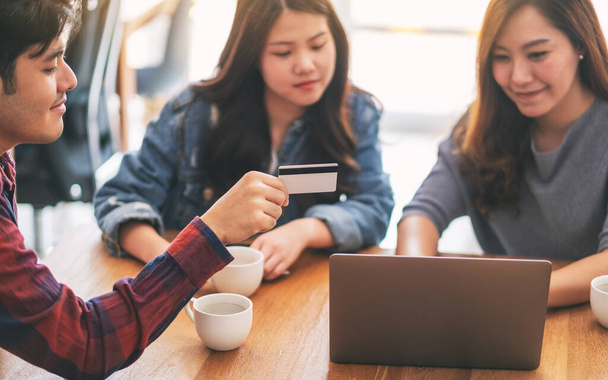 Tres jóvenes asiáticos usan tarjeta de crédito para comprar y comprar en línea  - Foto, imagen