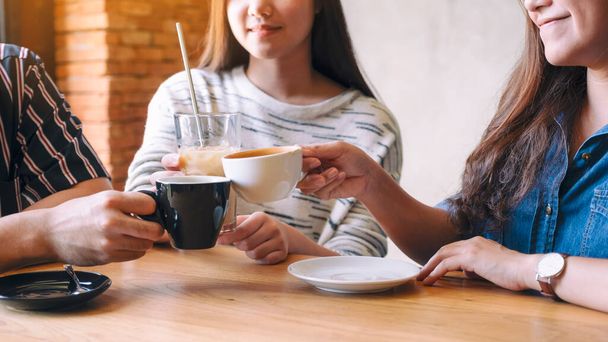 Imagen de cerca de la gente tintineo y beber café juntos en la cafetería - Foto, imagen