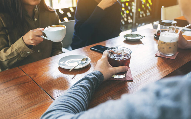 Nahaufnahme von Menschen, die gemeinsam im Café Kaffee trinken - Foto, Bild