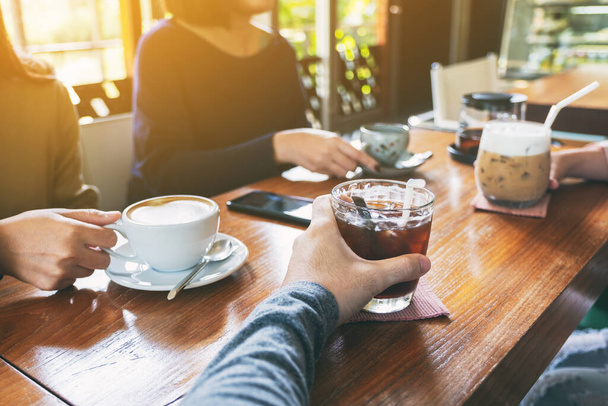 Close-up beeld van mensen genoten van het drinken van koffie samen in cafe - Foto, afbeelding