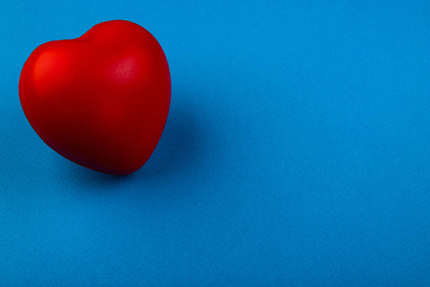 Red volumetric heart on a blue background - 写真・画像