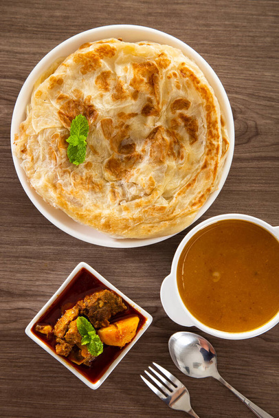 Roti Parata ou Roti canai com molho de caril de cordeiro - popular café da manhã malaio - Foto, Imagem