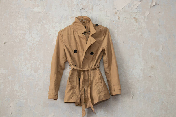 stylish womens brown raincoat hanging on white wall at home - Photo, Image