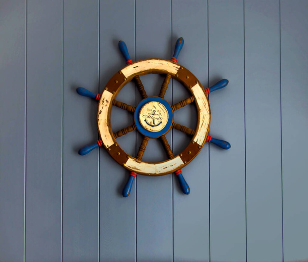 Корабельне колесо на дерев'яній стіні
 - Фото, зображення