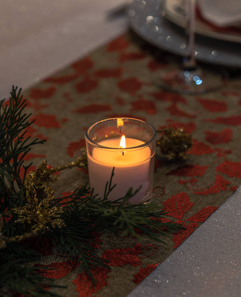 Primo piano con la luce romantica della candela accesa sul tavolo festivo. - Foto, immagini