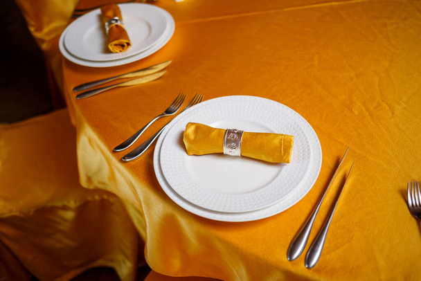 Tyylikäs kattaus haarukalla, veitsellä ja kultaisella lautasliinalla - Valokuva, kuva
