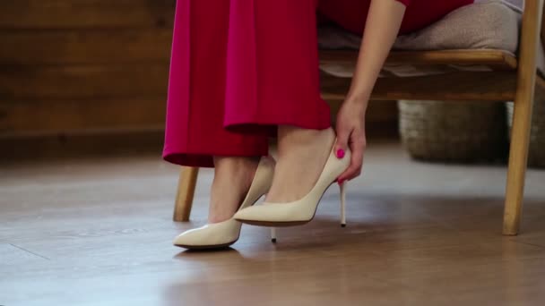 vermoeide zakenvrouw doet haar schoenen uit na een lange dag. zwelling van de voeten na hoge hakken, zachte focus. Selectieve focus. Een slow motion video. Video - Video