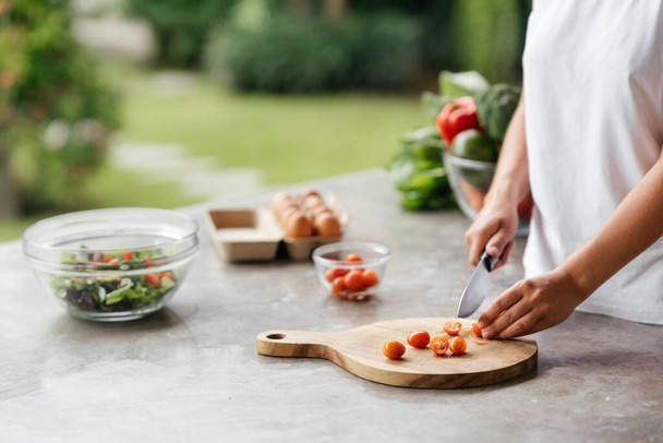 Human hands cooking vegetables salad in kitchen - Фото, изображение