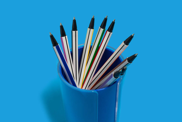 pens lying in a blue penholder - Fotó, kép