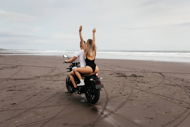 Young couple riding motorcycle on the beach - Fotoğraf, Görsel