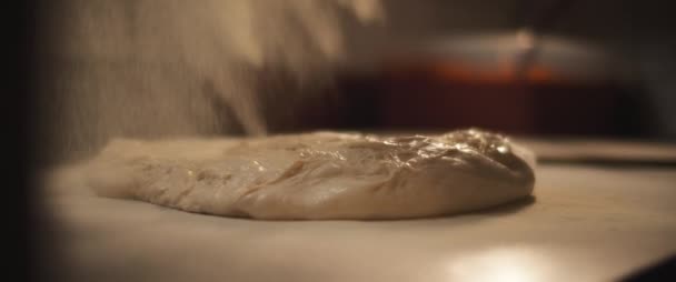 La farina bianca viene distribuita su un impasto fresco impreparato della pizza italiana. - Filmati, video