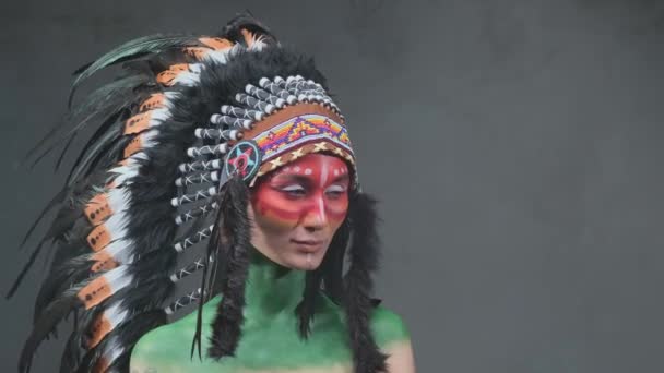 Joyeuse femme avec une coiffure indienne tribale dans un fond sombre et fumé - Séquence, vidéo