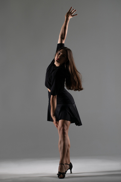 Молода професійна танцівниця практикує в студії, Молода Жінка в чорному платті танцює, танцює - Фото, зображення