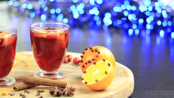 Dvě sklenice svařeného vína rotujícího na tácu s pomerančem a cynamonem - Záběry, video