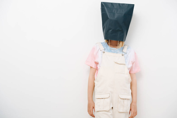 Young girl hid from the problems by putting a bag over her head and was offended - Foto, imagen