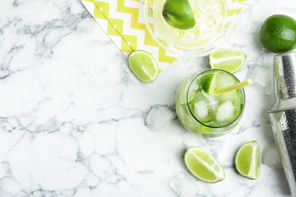 Delicious mojito and ingredients on white marble table, flat lay. Space for text - Foto, Imagem