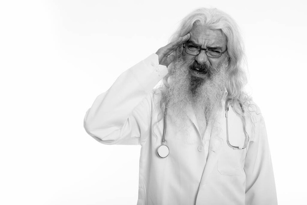 Stúdió lövés stresszes idősebb szakállas férfi orvos, amelynek fejfájás - Fotó, kép