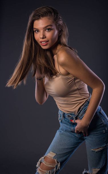 Portrait of an attractive stylish woman posing against dark background - Foto, Imagem