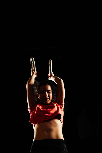 Entrenamiento de mujer deportiva con anillos de gimnasia en el centro de gimnasio crossfit - Foto, imagen