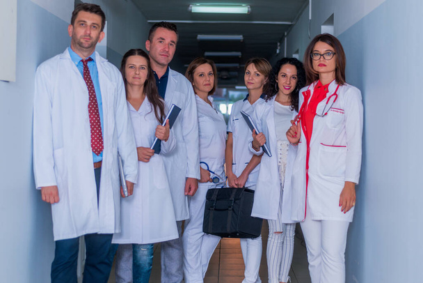 Grupo de personal médico, médicos de equipo y enfermeras posando en el pasillo de un hospital, clínica
. - Foto, Imagen