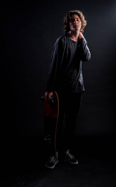 Body shot of an attractive male model holding his stylish skateboard - 写真・画像