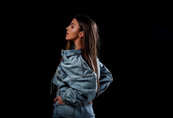 Portrait of a beautiful female model posing in trendy denim jacket and blue jeans - Fotografie, Obrázek