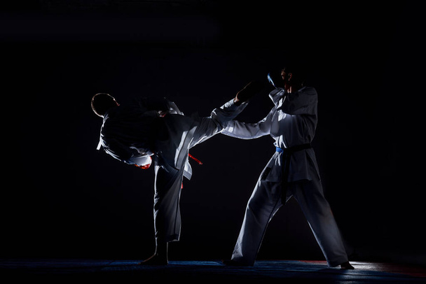 Jovem desportivo homem em kimono branco formação karatê kata se move no ginásio - Foto, Imagem