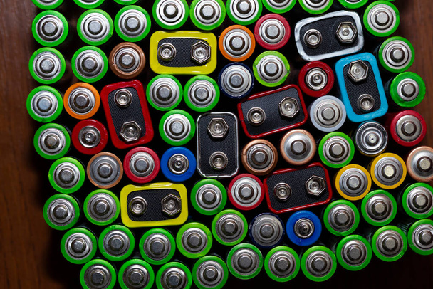 Použité alkalické baterie formát velikosti AA různých značek ležících v řádcích. horní pohled na pozadí textury elektrických baterií a akumulátorů AA. AA sbalené blízko u sebe. Použité baterie AA - Fotografie, Obrázek