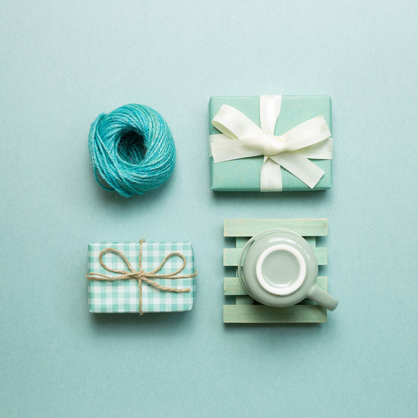 Gift boxes, coffee cup, string roll on mint green background. flat lay, top view, copy space - Photo, Image
