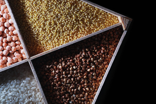 Ein Satz Getreide. Reis, Buchweizen und Hirsegrütze in Holzschale. Ein Lebensmittelgeschäft mit Getreide. Import von Getreide. - Foto, Bild