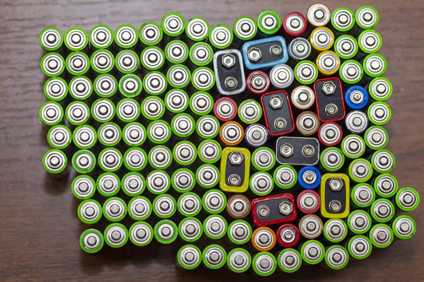 Використовуються лужні батареї формату AA різних марок, що лежать в рядах. текстура тла верхнього виду електричних батарей та акумуляторів AA. АА упаковані близько один до одного. Використовувані батареї AA
 - Фото, зображення