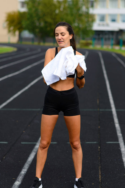 Yarış pistinde koşan genç bir bayan sporcunun açık hava çekimi. Koşu antrenmanı sırasında profesyonel sporcu.. - Fotoğraf, Görsel