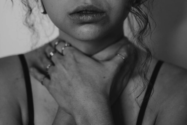 A grayscale shot of a young female with her hand on the neck, woman natural beaut - Photo, Image