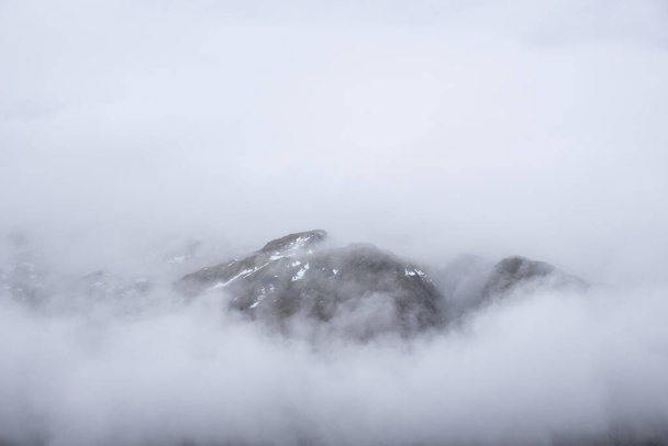 Baş döndürücü kış manzarası. Yan Pike 'tan Langdale mızraklarına doğru. Dağın tepesinde alçak seviye bulutlar ve karamsar sis var. - Fotoğraf, Görsel