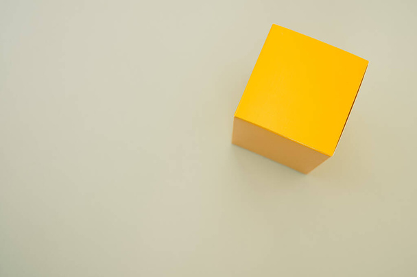 A yellow paper cube isolated on a grey background - Photo, image
