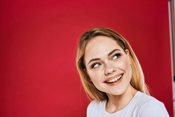 Όμορφη γυναίκα χαμόγελο λευκό t-shirt κομμένα κλαδιά κόκκινο φόντο - Φωτογραφία, εικόνα