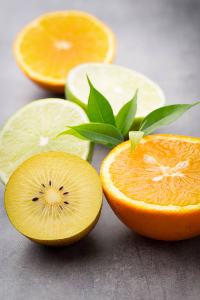 Mixed citrus fruit lemons, orange, kiwi, limes on a gray background.  - Fotoğraf, Görsel