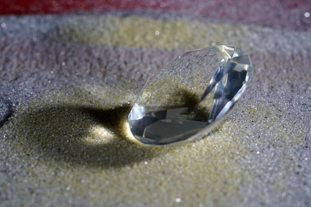A closeup shot of a beautiful expensive diamond and its shadow on the shiny surface - Foto, immagini