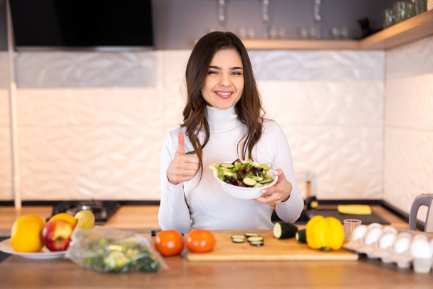 Portret młoda ładna kobieta stoi w kuchni gospodarstwa warzyw show rodziny przed gotowaniem - Zdjęcie, obraz