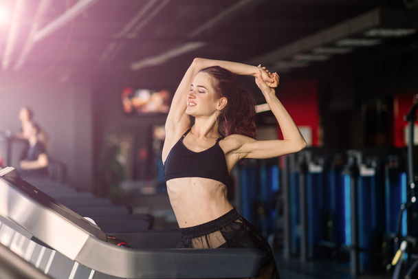 Молода жінка займається фітнесом і тренуванням під час бігу на трасі в спортивному клубі
 - Фото, зображення