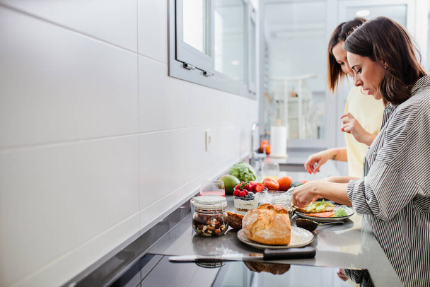 Dvě ženy připravují zdravé jídlo na kuchyňském pultu, diety a výživy - Fotografie, Obrázek