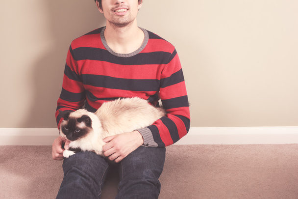 Young man and cat sitting on the floor - Photo, image