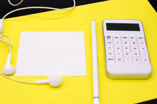 white calculator, pen and note paper on yellow background. Office table - Photo, image