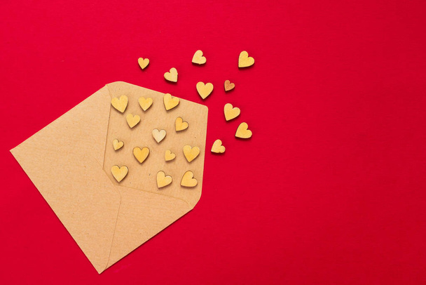 Small hearts fly out of the envelope on a red background. Copy space. - 写真・画像