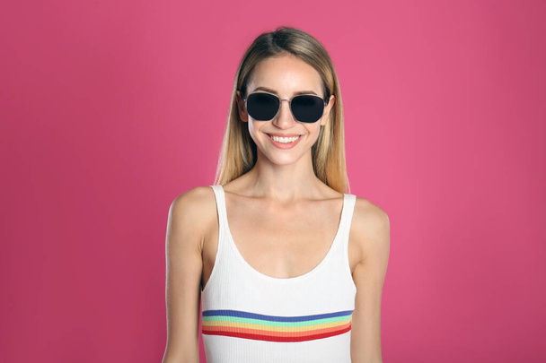 Beautiful woman in stylish sunglasses on pink background - Foto, afbeelding