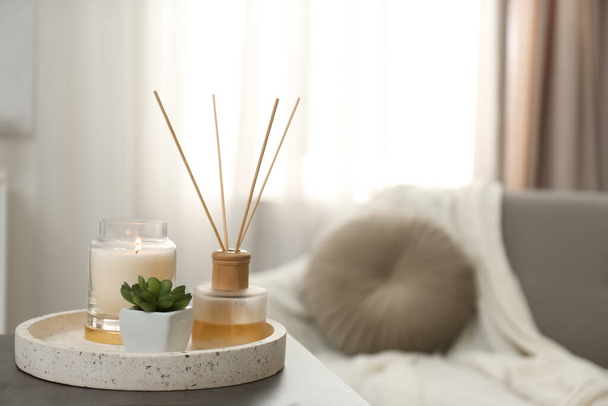 Air reed freshener, candle and plant on table in room, space for text - Φωτογραφία, εικόνα